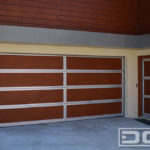 Eight panel double car garage door in Parklex, faux wood panels with a silver steel trim on the perimeter of each panel. A unique modern contemporary garage door for a high end beachfront property.